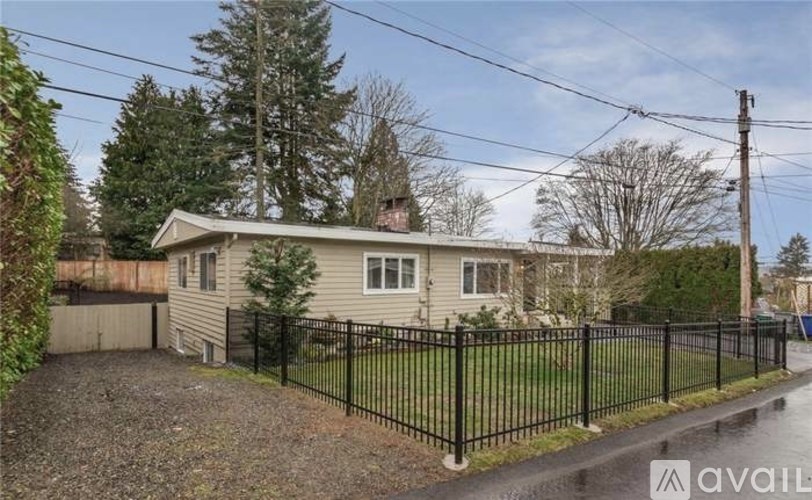 A house with a black fence is for sale.