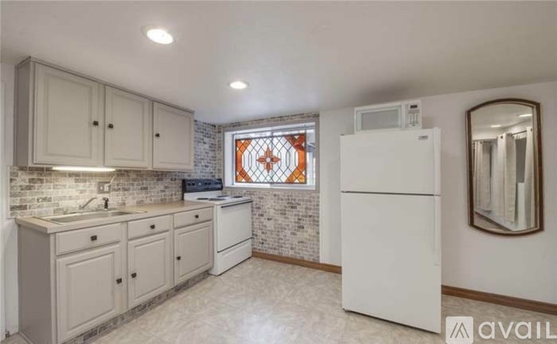A kitchen with white cabinets and a white refrigerator.