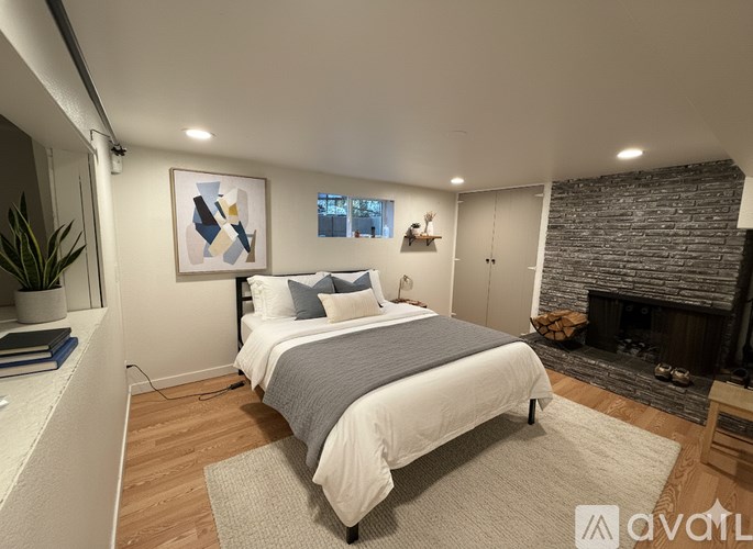 A bedroom with a large bed and a fireplace.