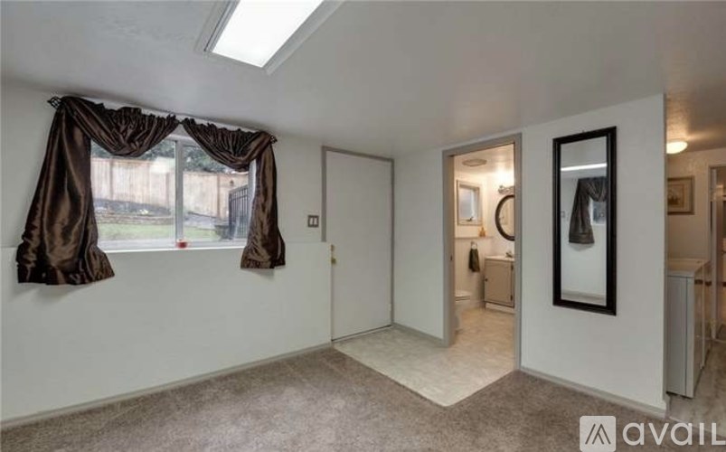A room with a window covered by brown curtains and a carpet on the floor.