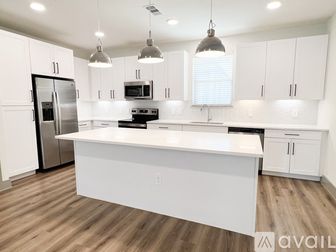 A modern kitchen with white cabinets and a central island.
