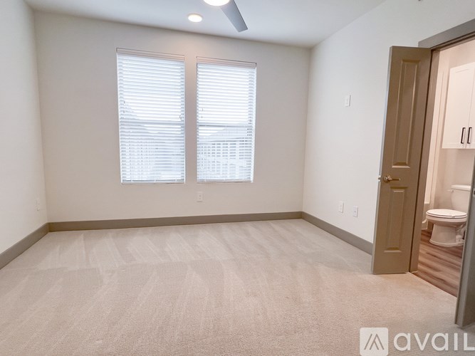 A room with a carpeted floor and a ceiling fan.