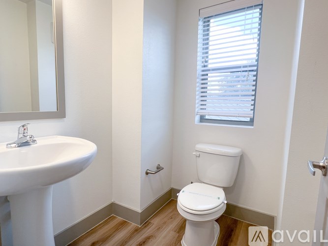 A white toilet in a bathroom with a sink and mirror.