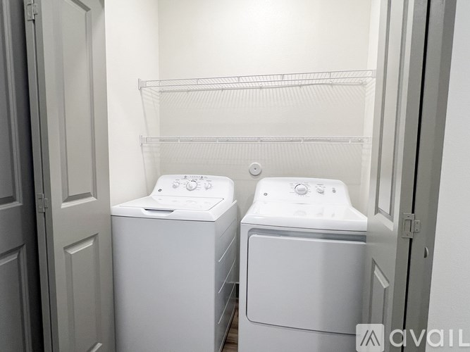 Two white front loading washing machines in a small laundry room.