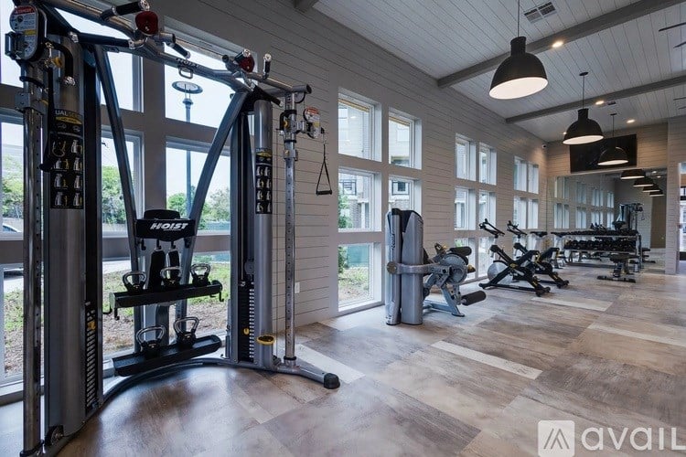 A gym with a variety of equipment including a squat rack and a treadmill.