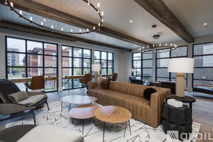 A living room with a brown couch, a black table, and a large window.