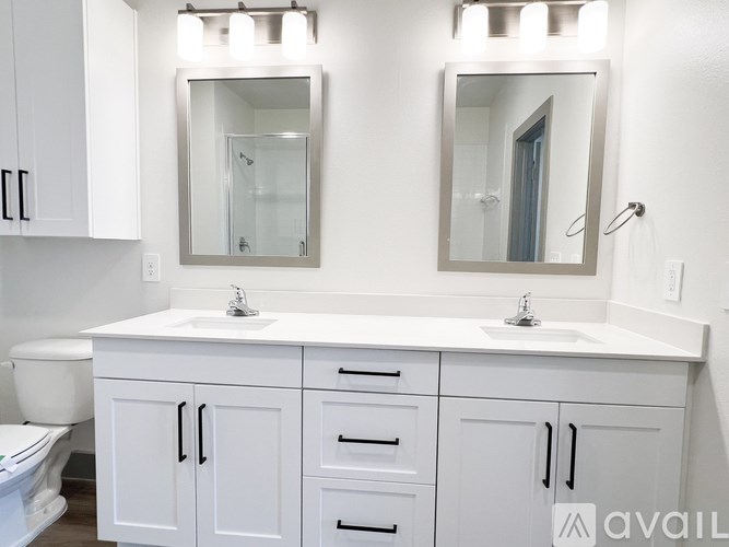A white bathroom with a vanity and a toilet.