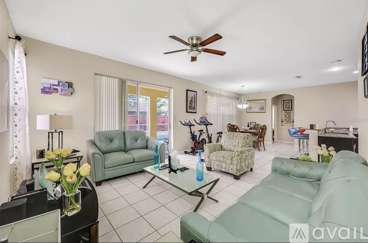 A living room with a ceiling fan and a variety of furniture.