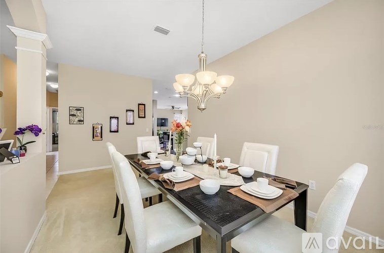 A dining room with a table set for a meal.