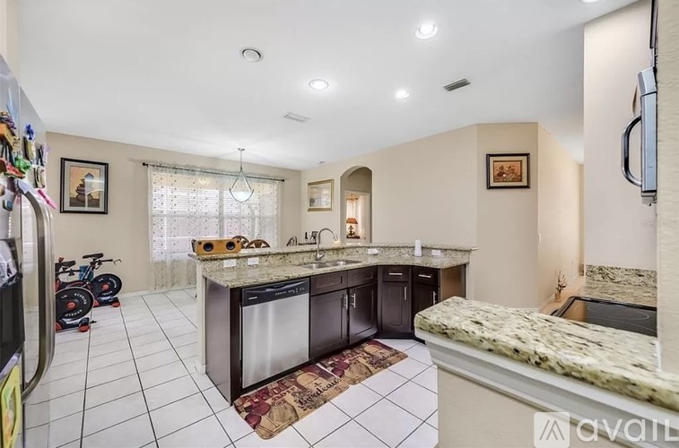 A kitchen with granite countertops and a refrigerator with magnets on the door.