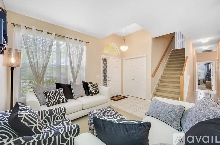 A living room with a white couch and a zebra print chair.