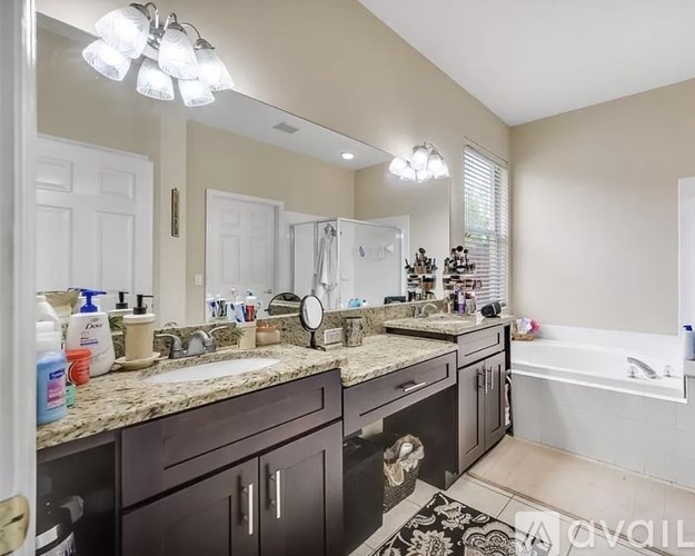 A bathroom with a large mirror, a sink, and a bathtub.
