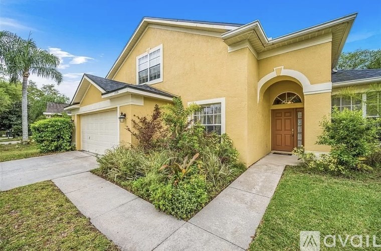 A yellow house with a brown door and a garage.