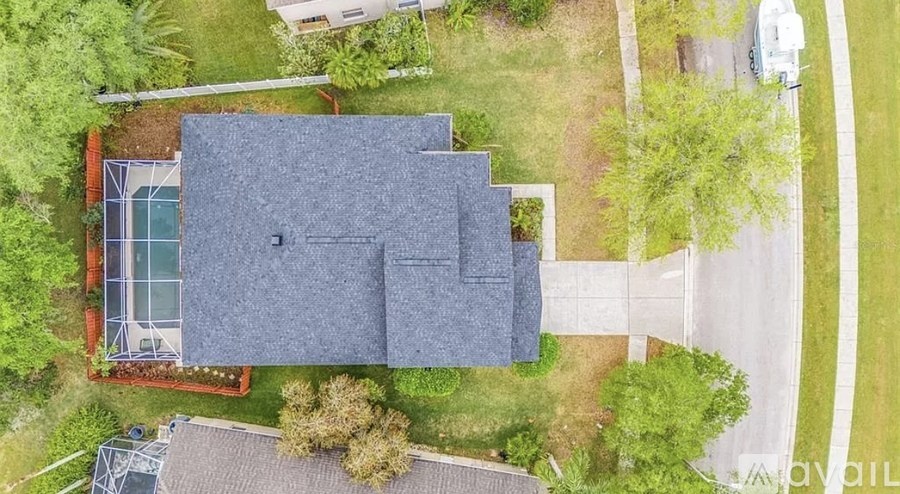 A house with a grey roof and a tennis court.