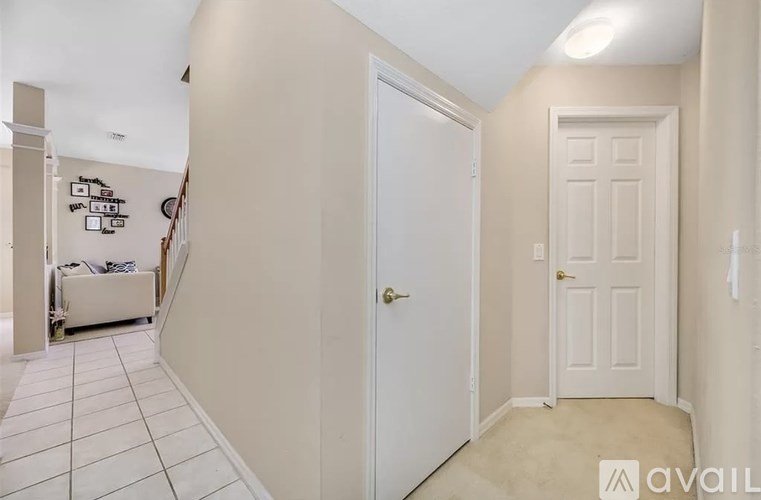 A hallway with a white door and a white wall.
