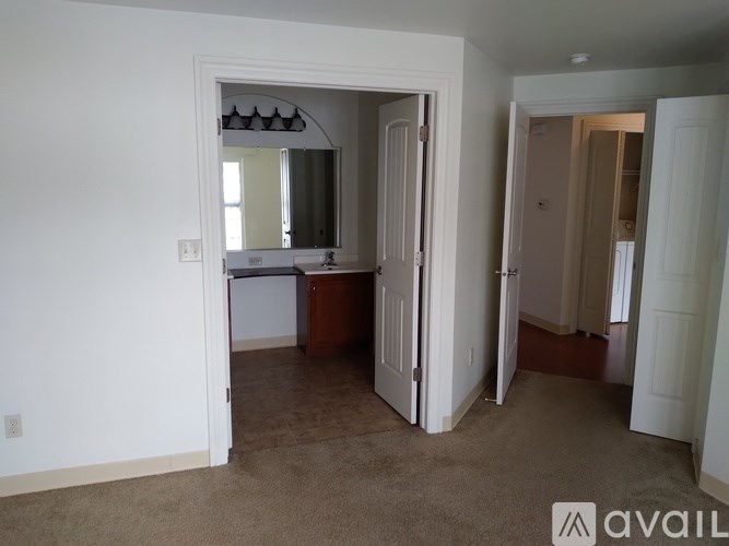 A room with a carpeted floor and a mirror on the wall.