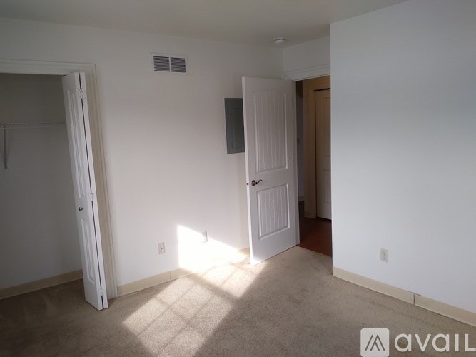 A room with a carpeted floor and a door on the left side.