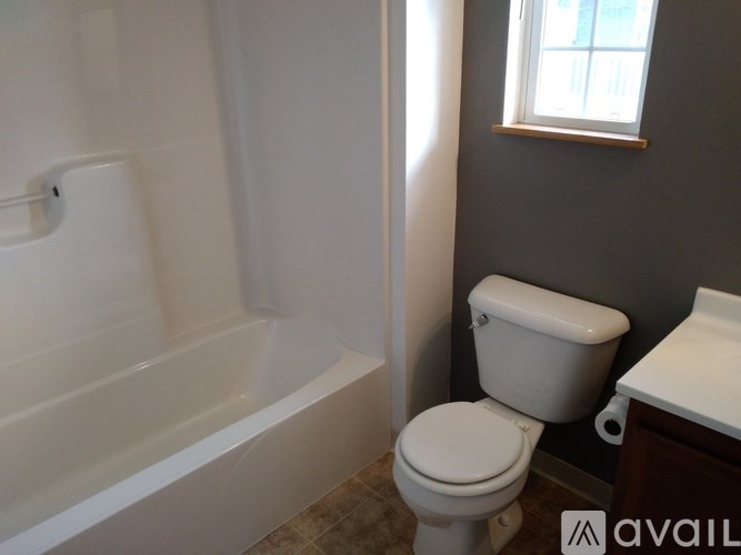 A white toilet sits next to a bathtub in a bathroom.