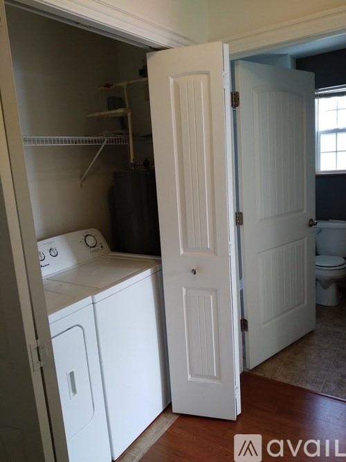 A white door is open to a laundry room.