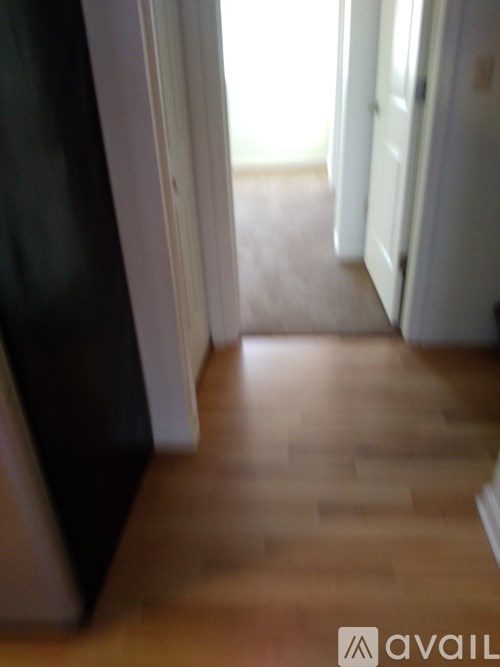 A hallway with wooden floors and white walls.