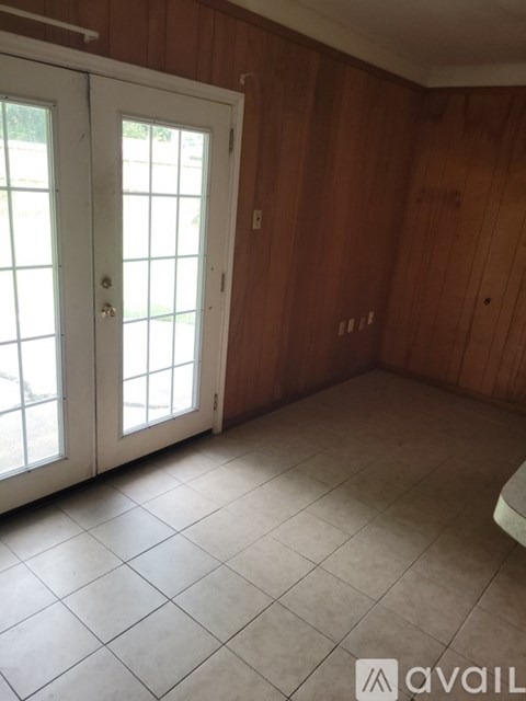 A room with a white door and wooden walls.