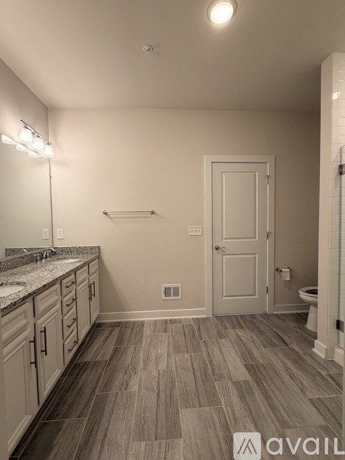A bathroom with a sink, mirror, and toilet.