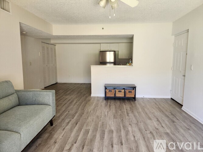 A living room with a grey couch and a wooden floor.
