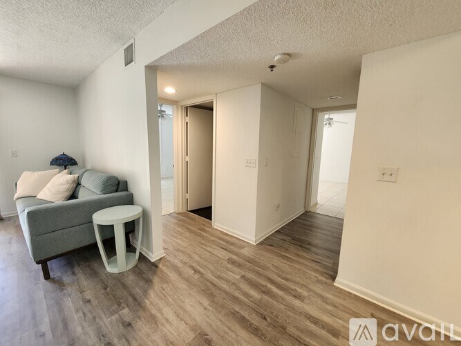 A living room with a grey couch and a white side table.