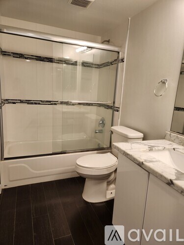 A white toilet sits in a bathroom next to a sink.