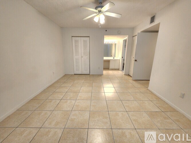 A spacious room with a fan and tiled flooring.