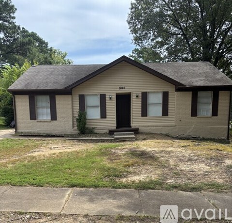 A beige house with a black door and windows.