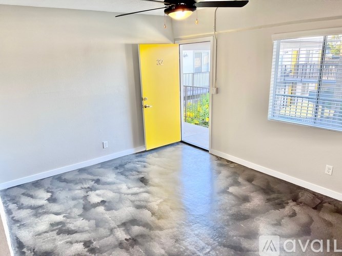 A room with a yellow door and a ceiling fan.
