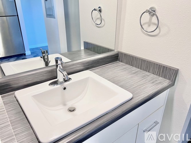A white sink is in a modern bathroom with a mirror above it.