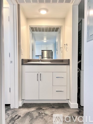 A kitchen with white cabinets and a marble floor.