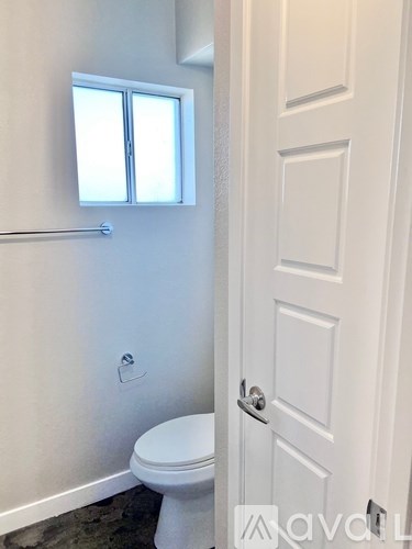 A white toilet in a bathroom with a white door.