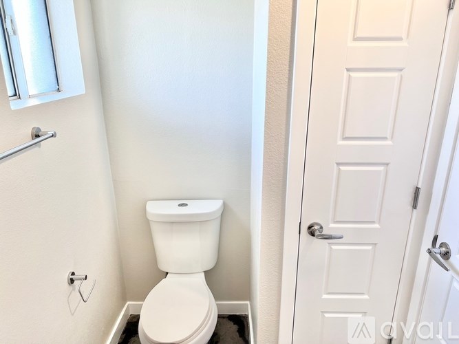 A white toilet in a small bathroom with a white door.