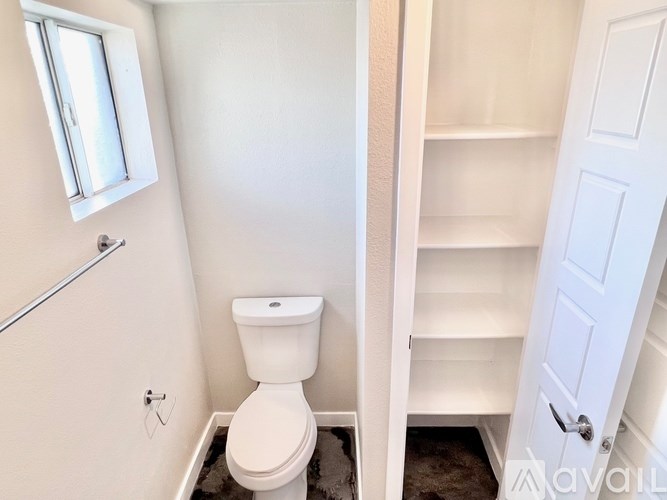 A white toilet in a small bathroom with a white door.