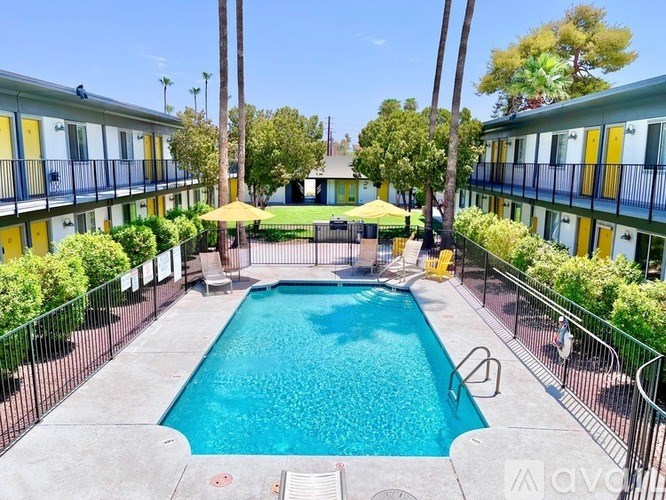A pool surrounded by a fence and trees.