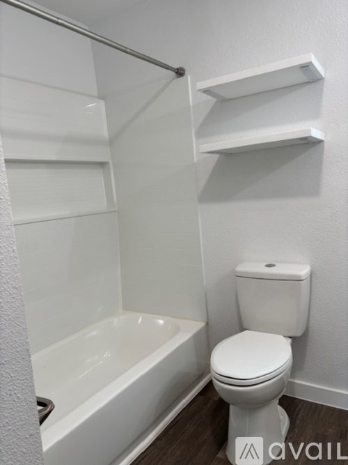 A white toilet sits next to a bathtub in a bathroom.