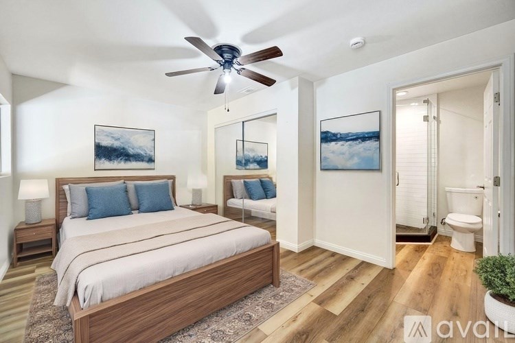 A bedroom with a large bed and a ceiling fan.