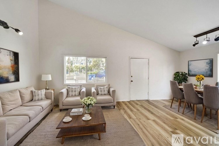 A living room with a couch, chairs, and a coffee table.