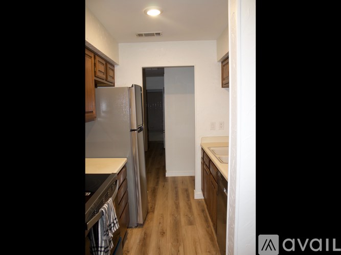 A kitchen with a refrigerator, sink, and cabinets.