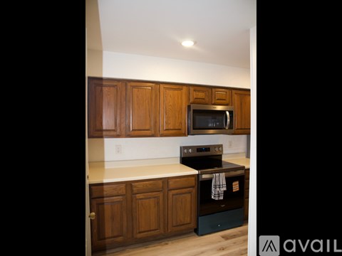 A kitchen with wooden cabinets and a stove top oven.