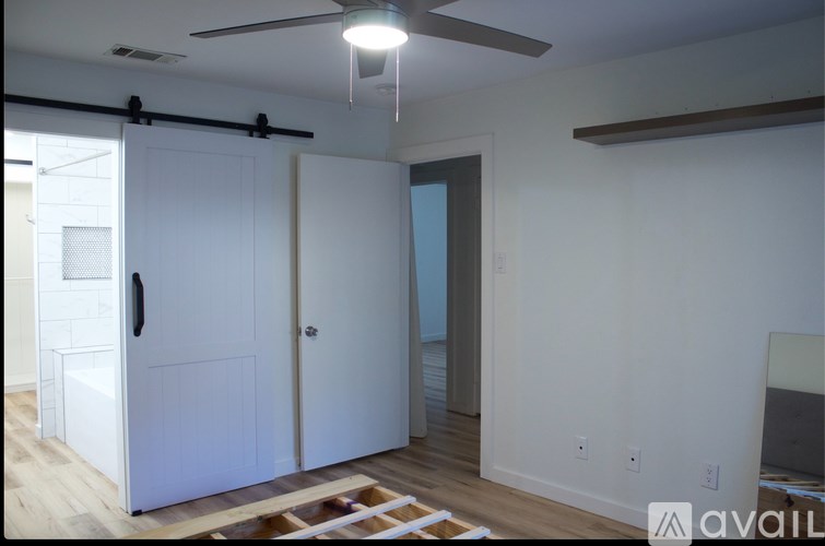 A room with a ceiling fan and a door.