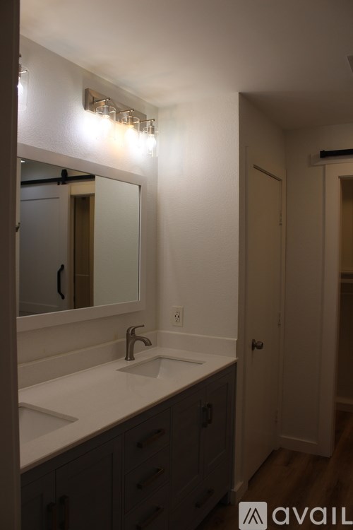 A bathroom with a sink, mirror, and lights.