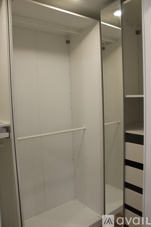A white walk-in closet with shelves and a mirror.
