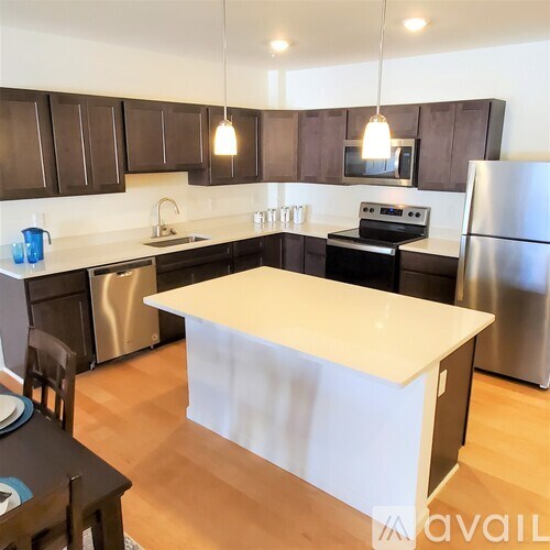 A kitchen with a white island in the middle.