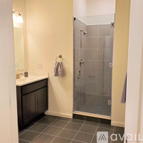 A bathroom with a glass shower door and a white sink.