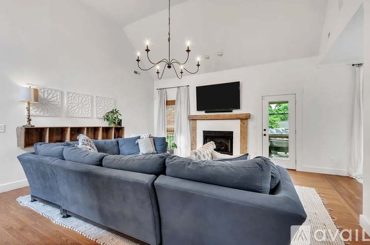 A grey couch is in front of a fireplace in a living room.
