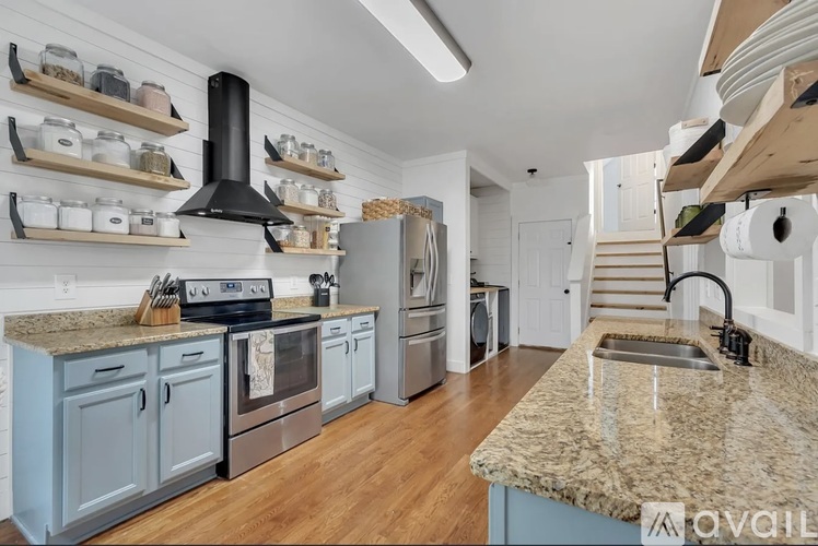 A kitchen with a granite countertop and a stove top oven.